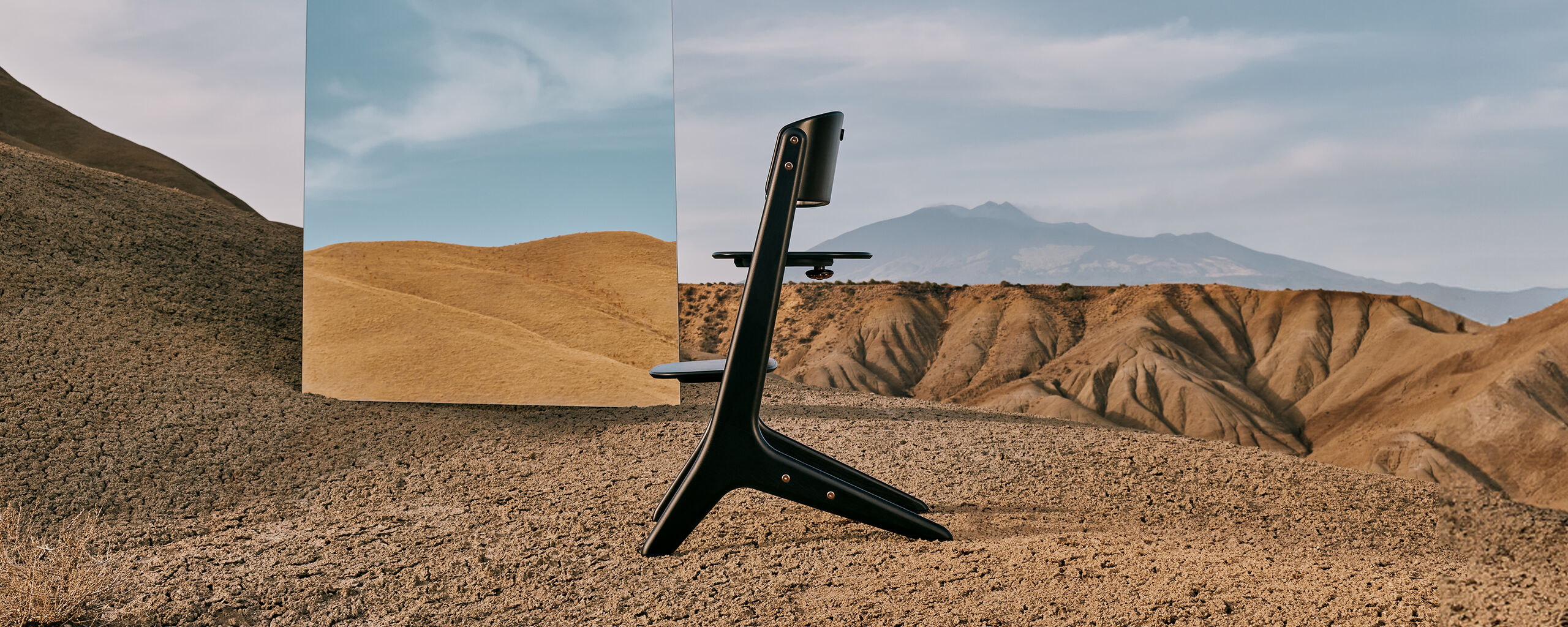 Lemo Platinum high chair in a desert landscape with mountains in the background.