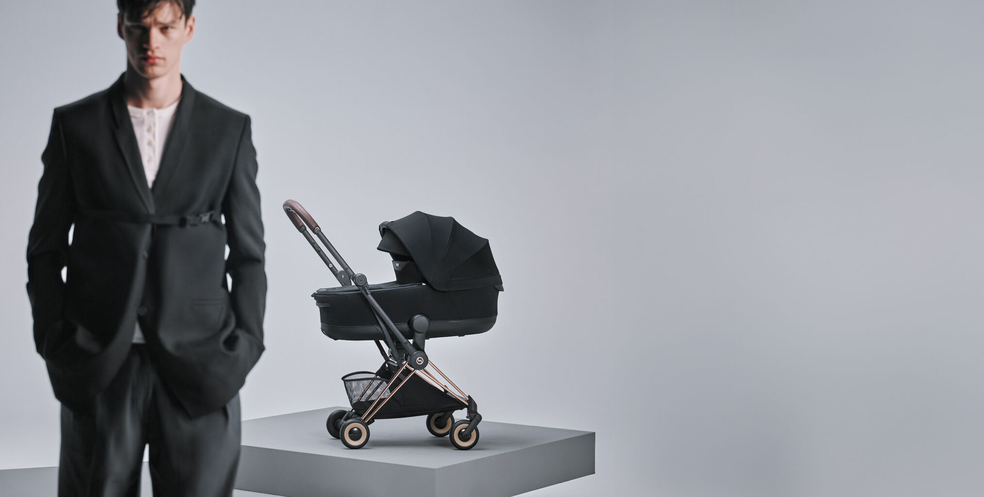 A man at the forefront, slightly blurry. Behind him, a Co&yuml;a Style with a Cot attached.