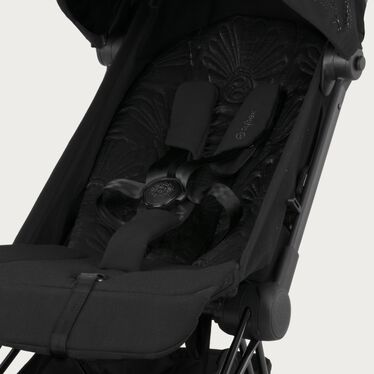 Image du CYBEX Platinum Coya - La Parisienne Buggy, mettant en avant la fonctionnalité Harnais ajustable à une main.