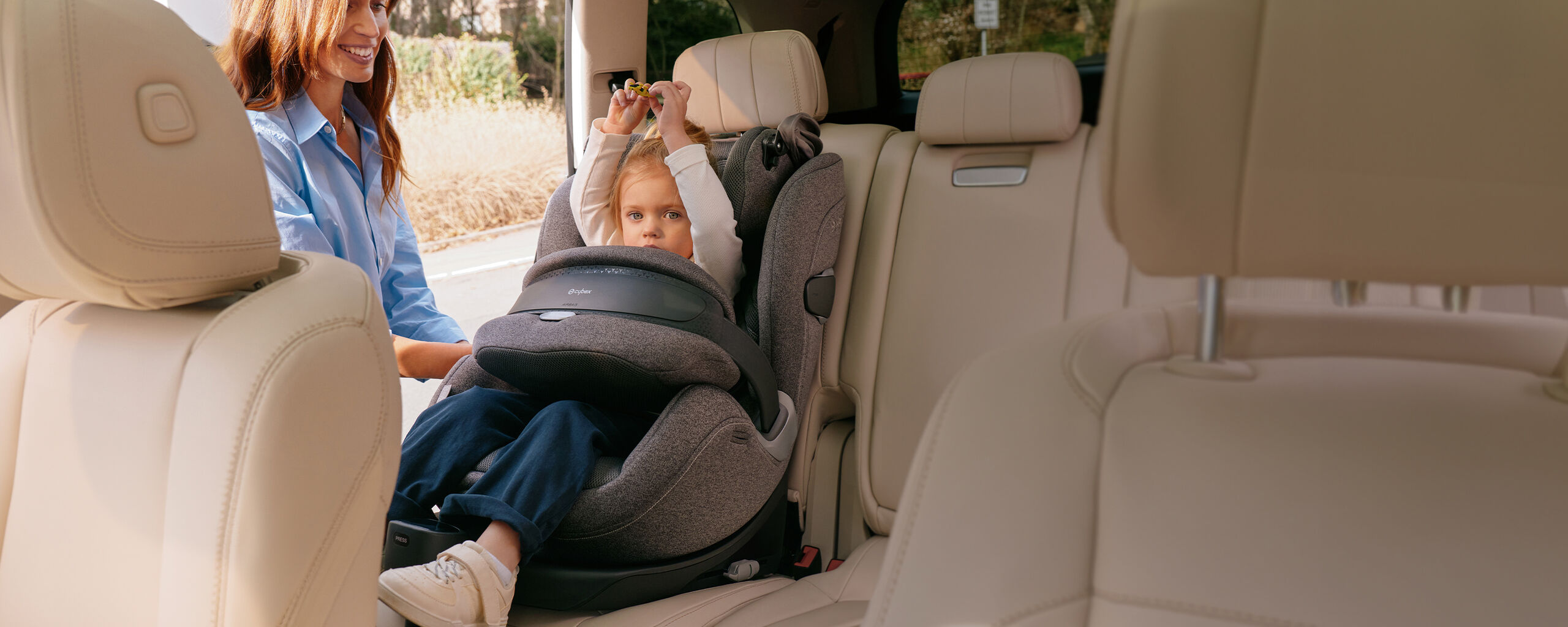 Moeder die haar kind vastmaakt in de Anoris T2 i-Size Plus autostoel met airbag in de auto.