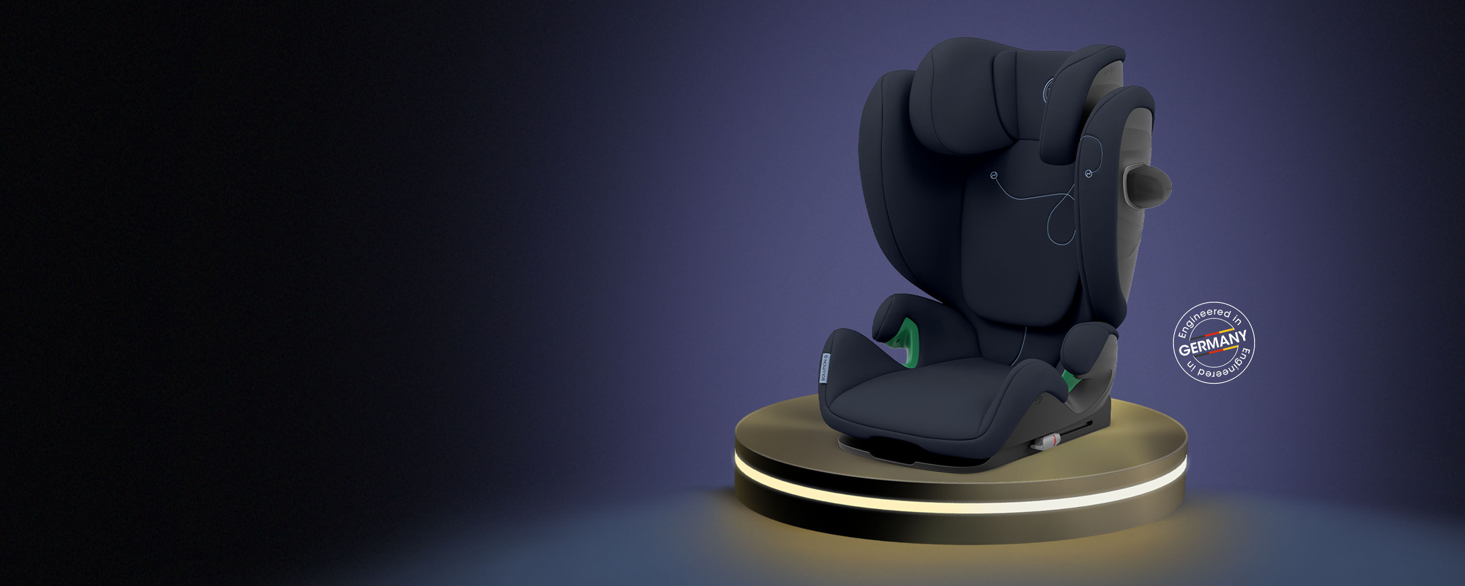 Een moderne zwarte kinderautostoel op een verlicht platform, met een "Engineered in Germany" zegel ernaast.