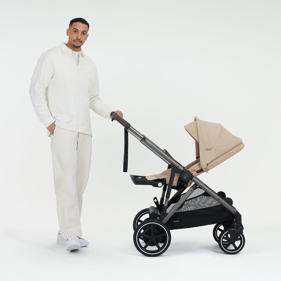 A woman pushing a Balios S Lux stroller, the sun canopy completely down.