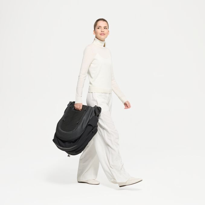 An image of the CYBEX Platinum Mios/Coya Fold Lux Carry Cot - Style Collection Stroller, highlighting the Integrated Carry Handle when Folded feature.