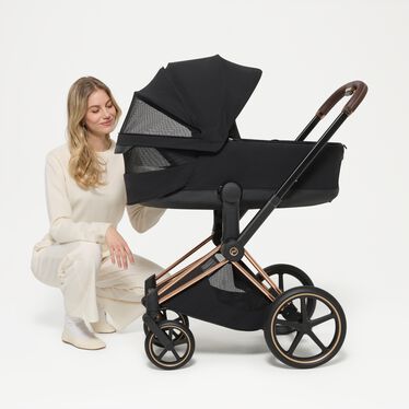 An image of the CYBEX Platinum Priam Fold Lux Carry Cot Stroller, highlighting the Panorama and Sky View Windows feature.