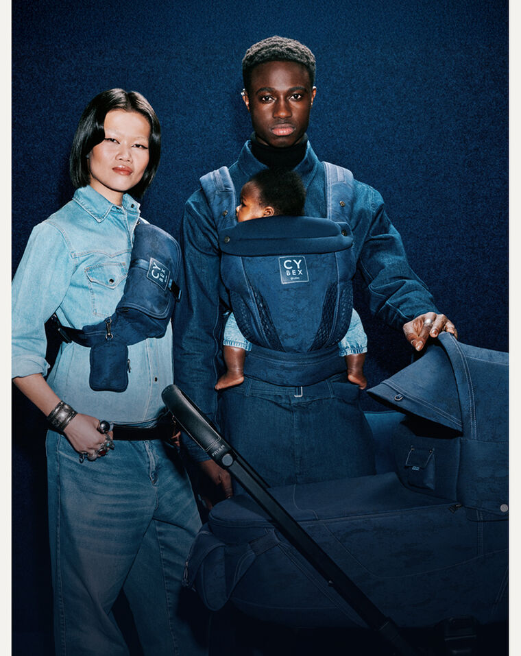 A woman on the left wearing a Rebellious Luxury Belt Bag, next to him, a man with one hand on a Rebellious Luxury stroller and a Rebellious Luxury carrier in which his child is safely nestled in.