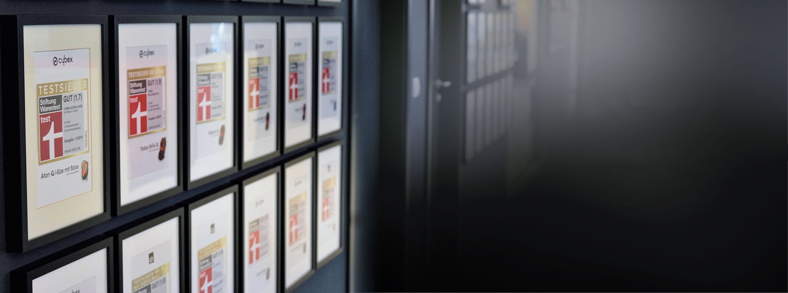 Wall with framed awards from Stiftung Warentest for Cybex products.