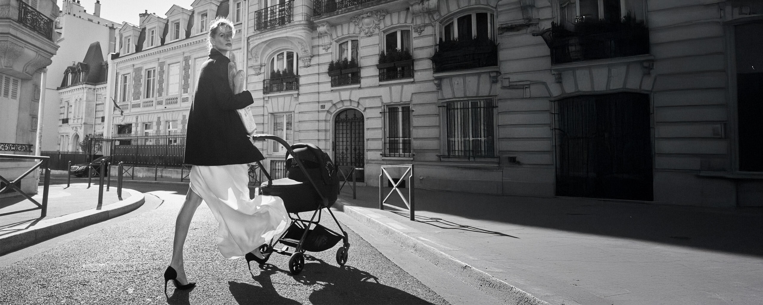 A woman in an elegant outfit with a stroller on a Parisian street