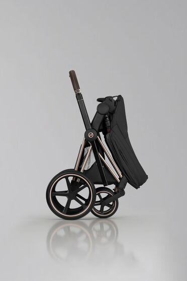 Product image of a folded up, self-standing Priam stroller.