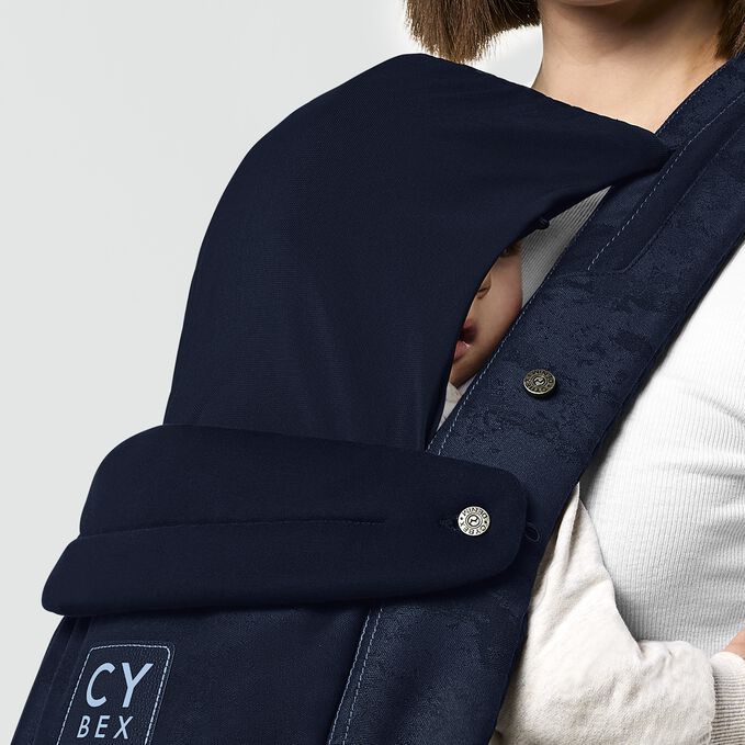 An image of the CYBEX Platinum Coya Carrier Rebellious Luxury Baby Carrier, highlighting the Integrated Head Cover feature.