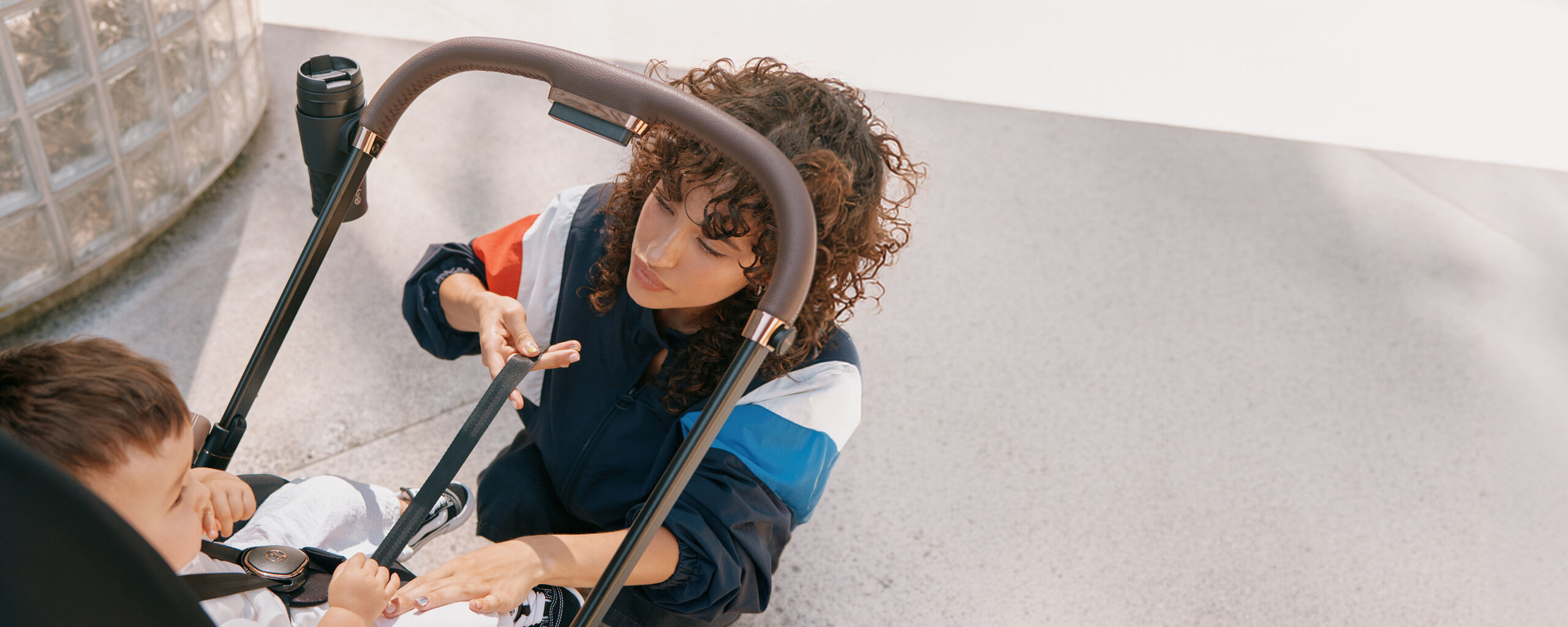 A child in a CYBEX stroller with a parasol attached to it.