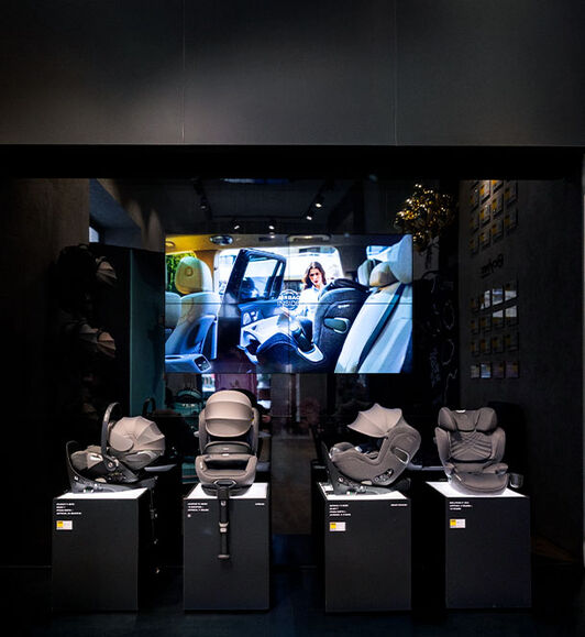 A display of CYBEX car seats in a darkly lit room.