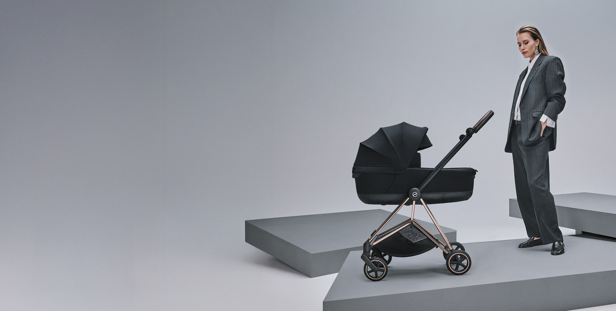 A woman standing next to a Mios Style stroller.