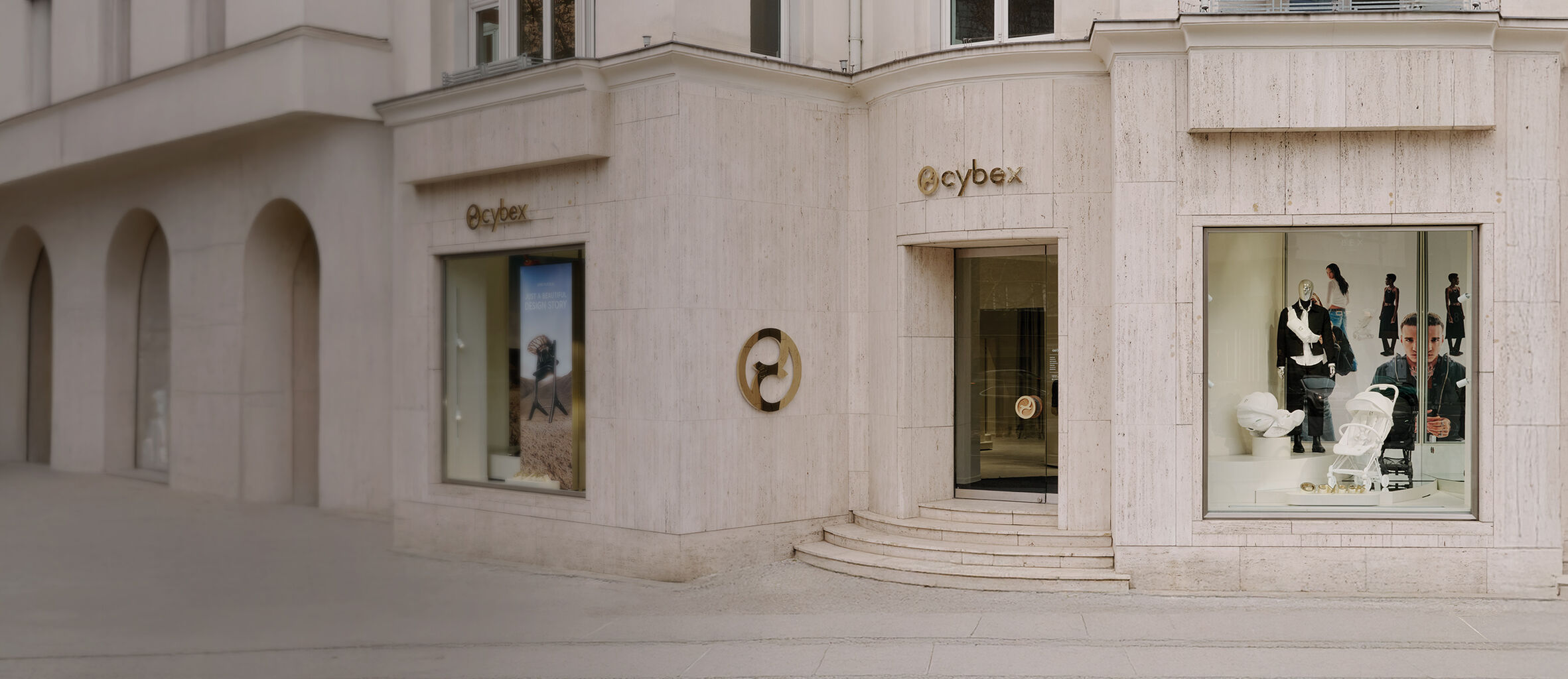 Three large display windows of the CYBEX store with elegant logo awnings. The glass reflects the historic old town fa&ccedil;ades, creating a striking contrast with the modern store design.
