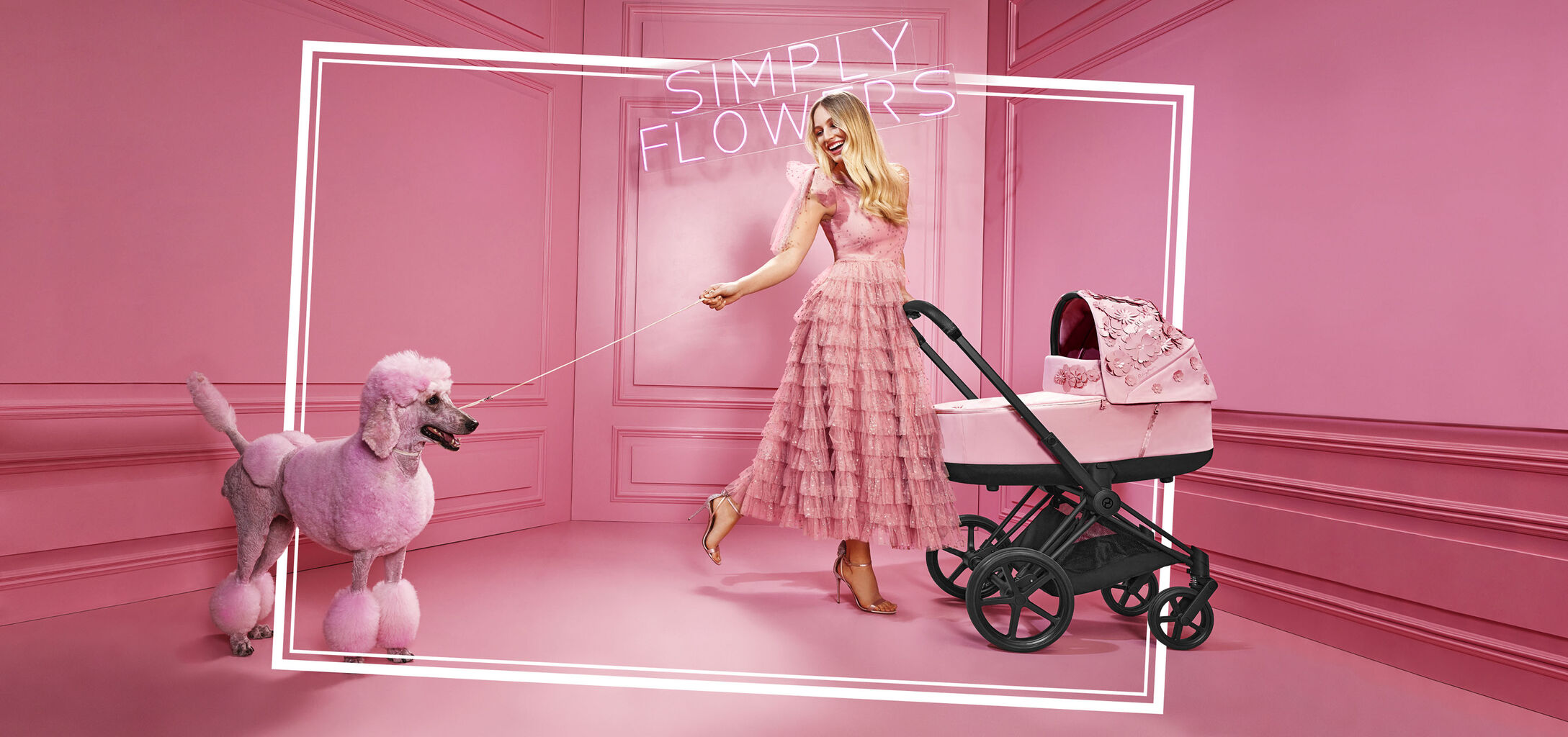 Woman in a pink dress with a pink poodle and a CYBEX Simply Flowers pram in a pink room.