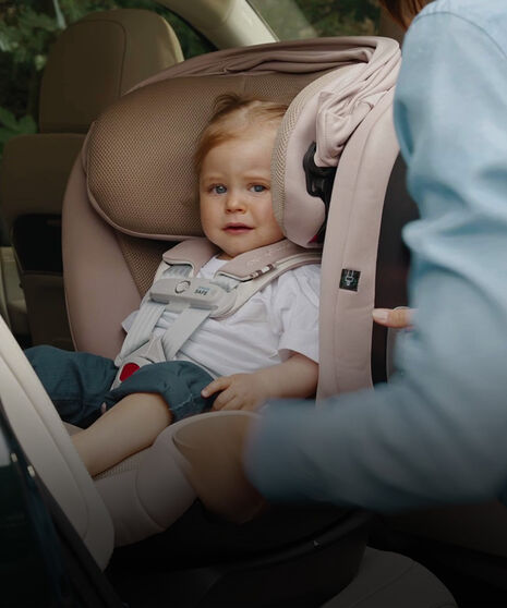 A child sitting in a rear-facing car seat. 