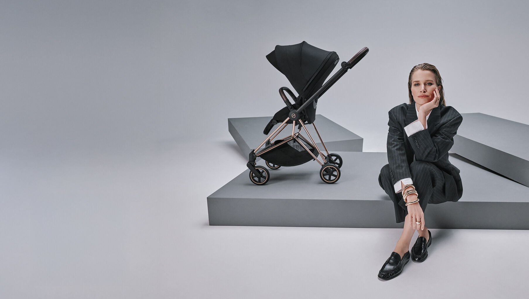 A woman sitting next to a Mios Style with a Seat Pack attached.