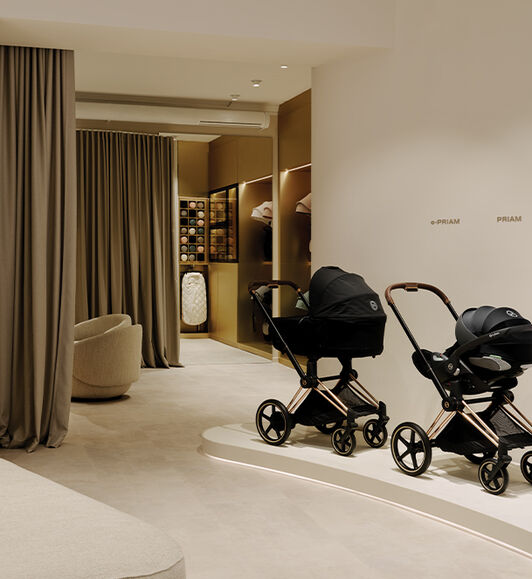 CYBEX e-Priam and Priam with a Cloud T attached on display to the right. Two curtains separating the store inside.