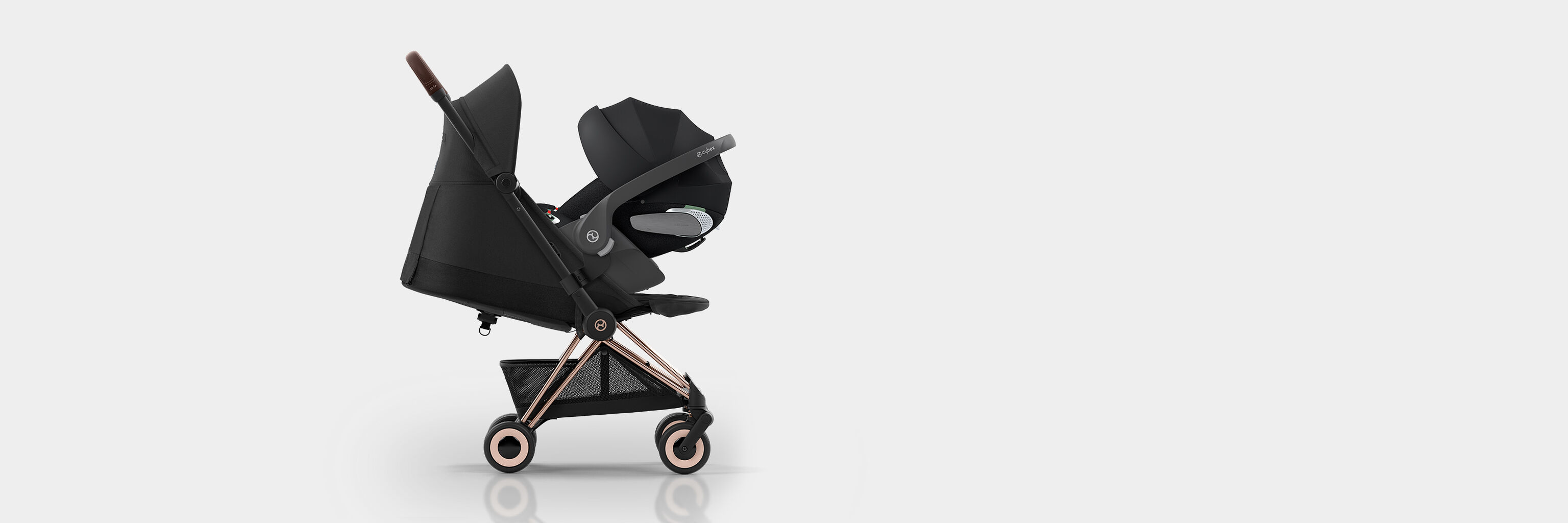 Side view of the Coya compact travel stroller, black with copper accents.