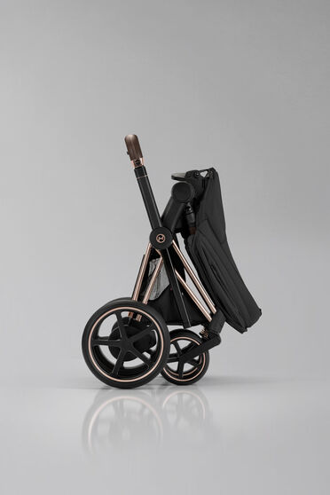 Product image of a folded up, self-standing Priam stroller.