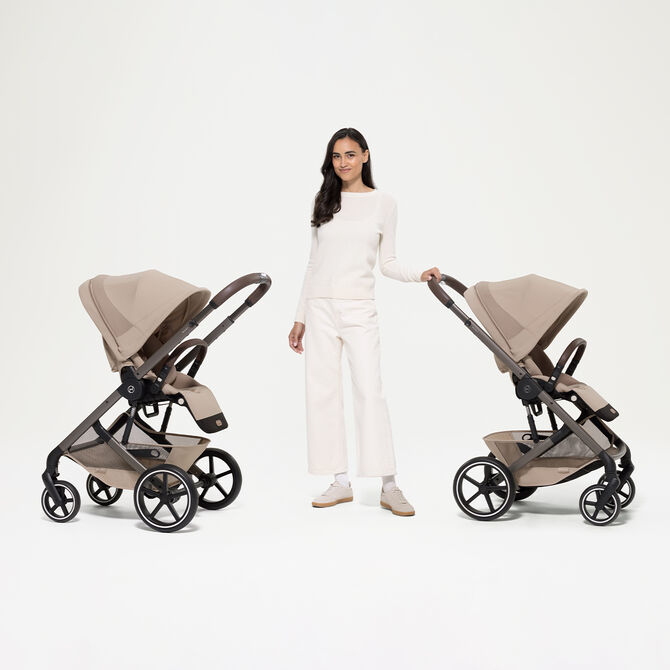 A woman next to two Balios S Lux strollers with seat units, both with different positions.