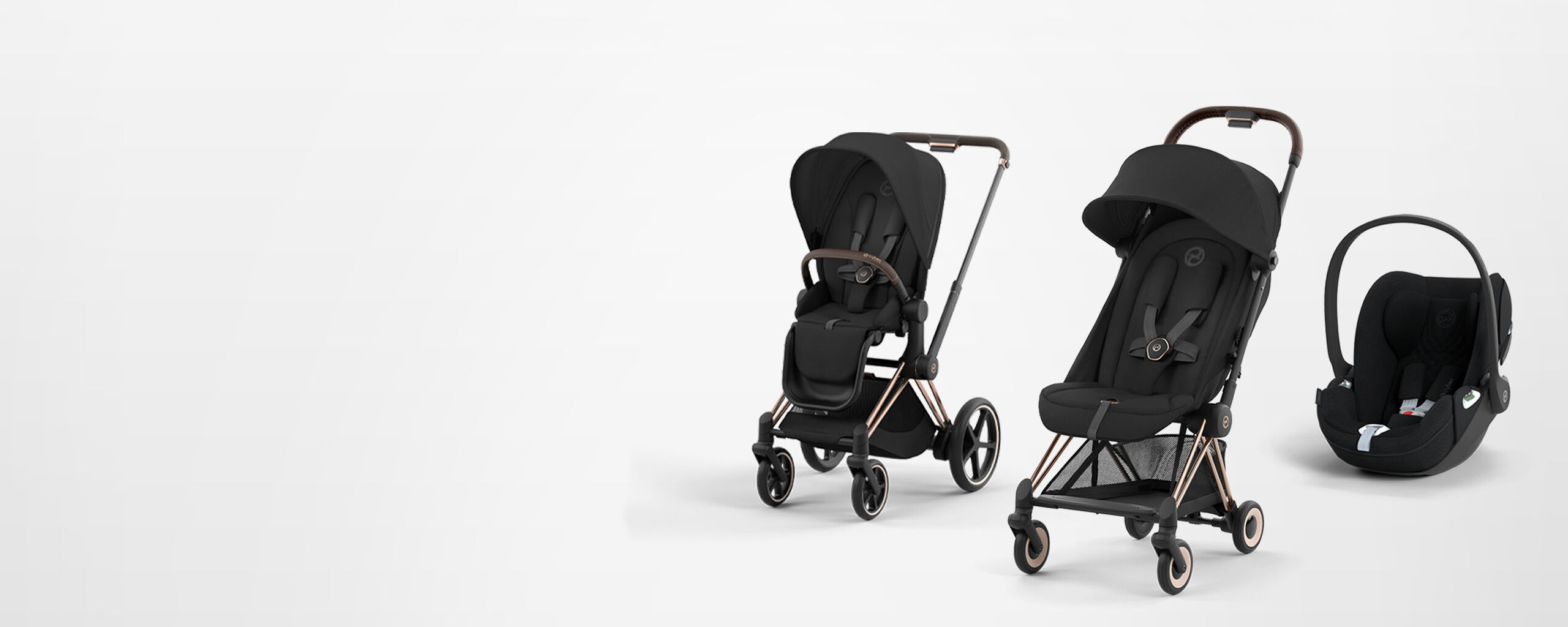Stroller set with two black pushchairs and a car seat on a white background.