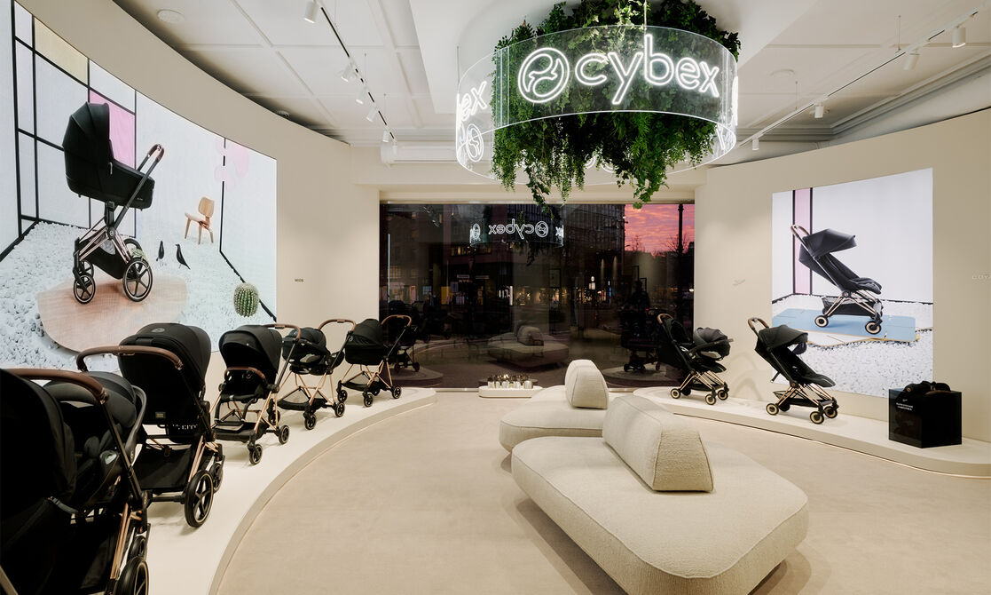 Two couches amidst a variety of CYBEX strollers inside the flagship store.