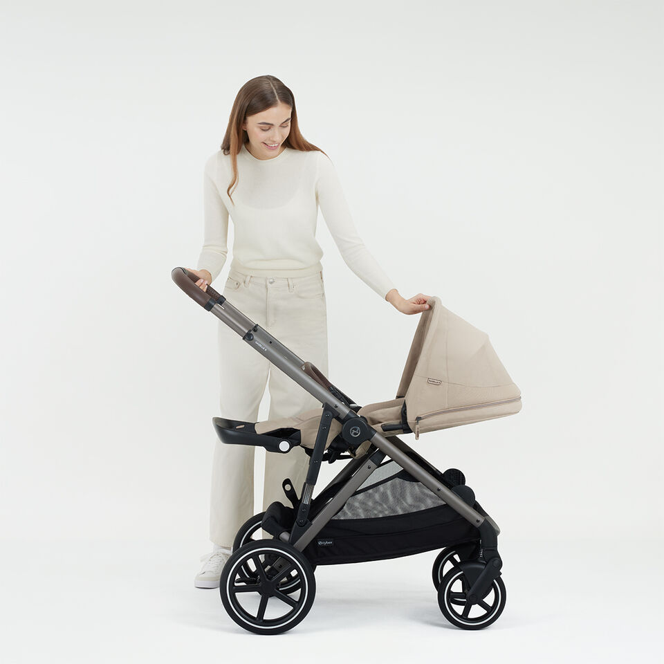 A woman bringing her Gazelle S stroller into an ergonomic lie-flat position.