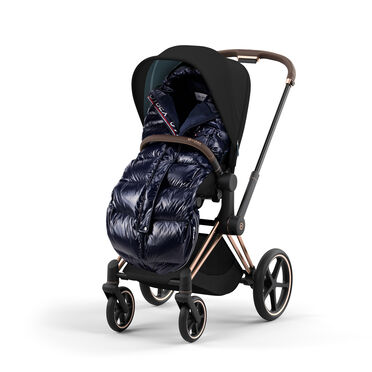 Pram with a black hood and shiny dark blue footmuff.