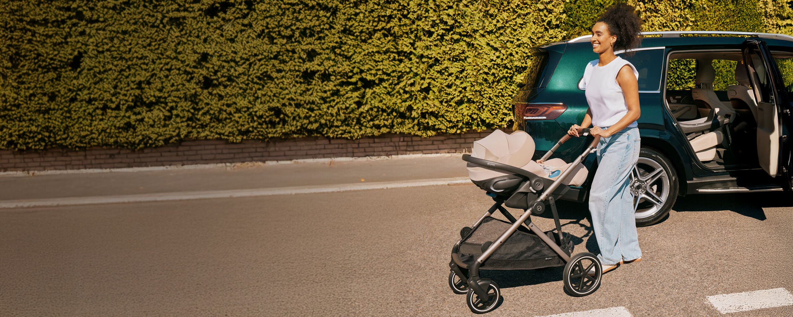 A woman walking away from her car with her Cloud G Pro infant car seat attached to a stroller frame.