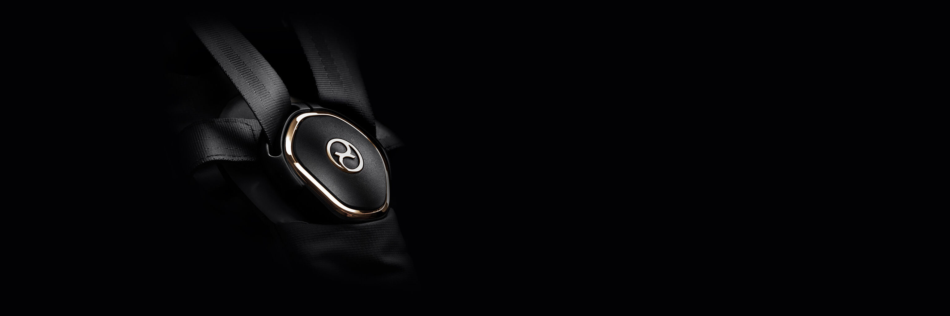 Close-up of an elegant black buckle with gold accents on the Priam luxury stroller.