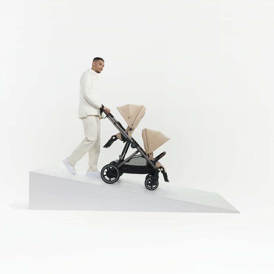 An image of the CYBEX Gold e-Gazelle S Sibling Stroller, highlighting the e-Powered Uphill and Uneven Surface Support feature.