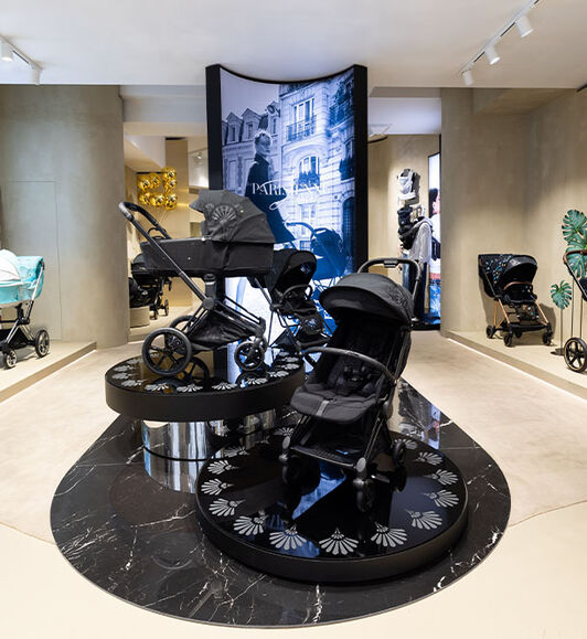 CYBEX interior: pushchair from the La Parisienne collection elegantly displayed on a black round marble pedestal.
