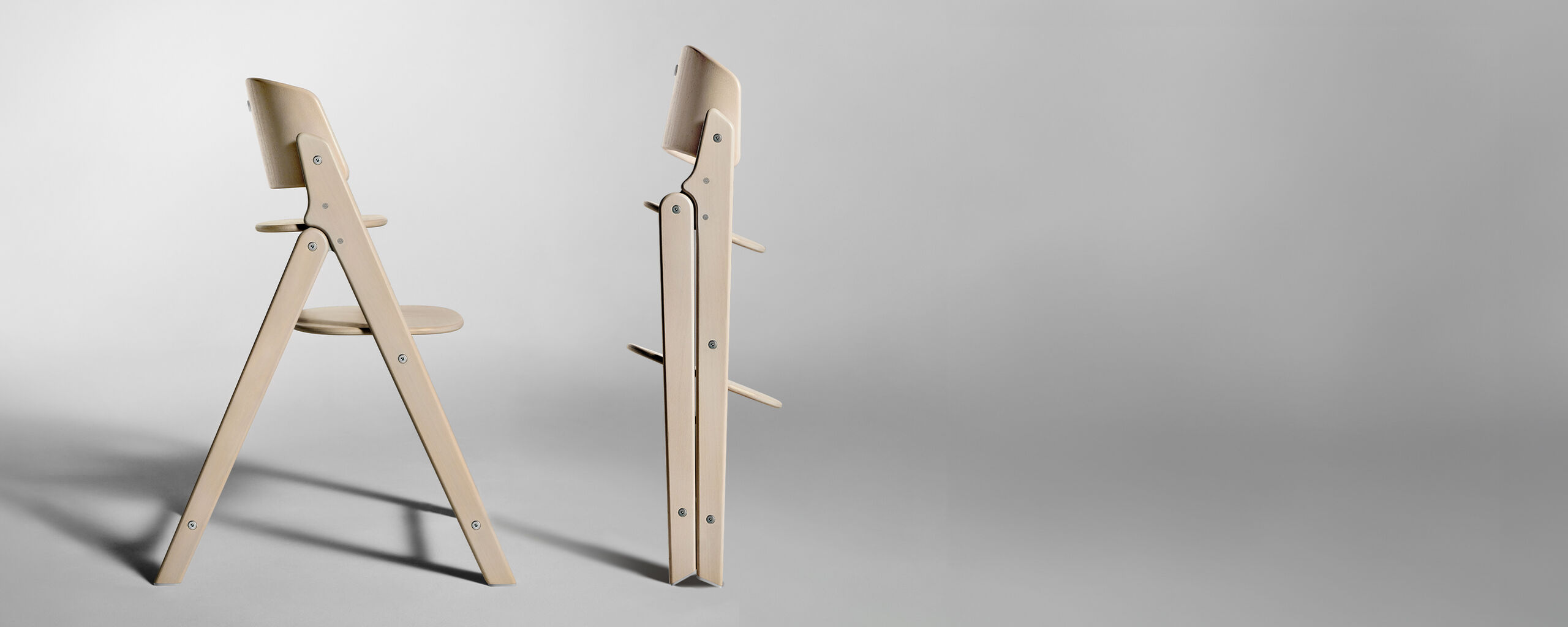 A modern, foldable wooden chair in a light wood tone, shown once open and once folded.