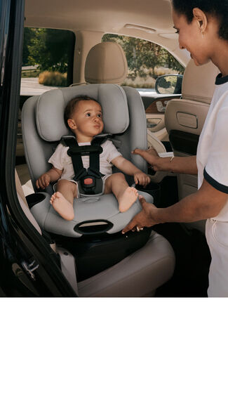 A mother turning her Callisto G 360 Select car seat with her child sitting in it towards the door.