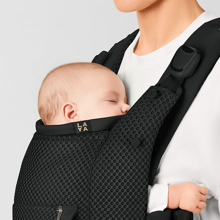 Close up of a baby sleeping in a Laya baby carrier with the cushioned neck support making it comfortable for the child.