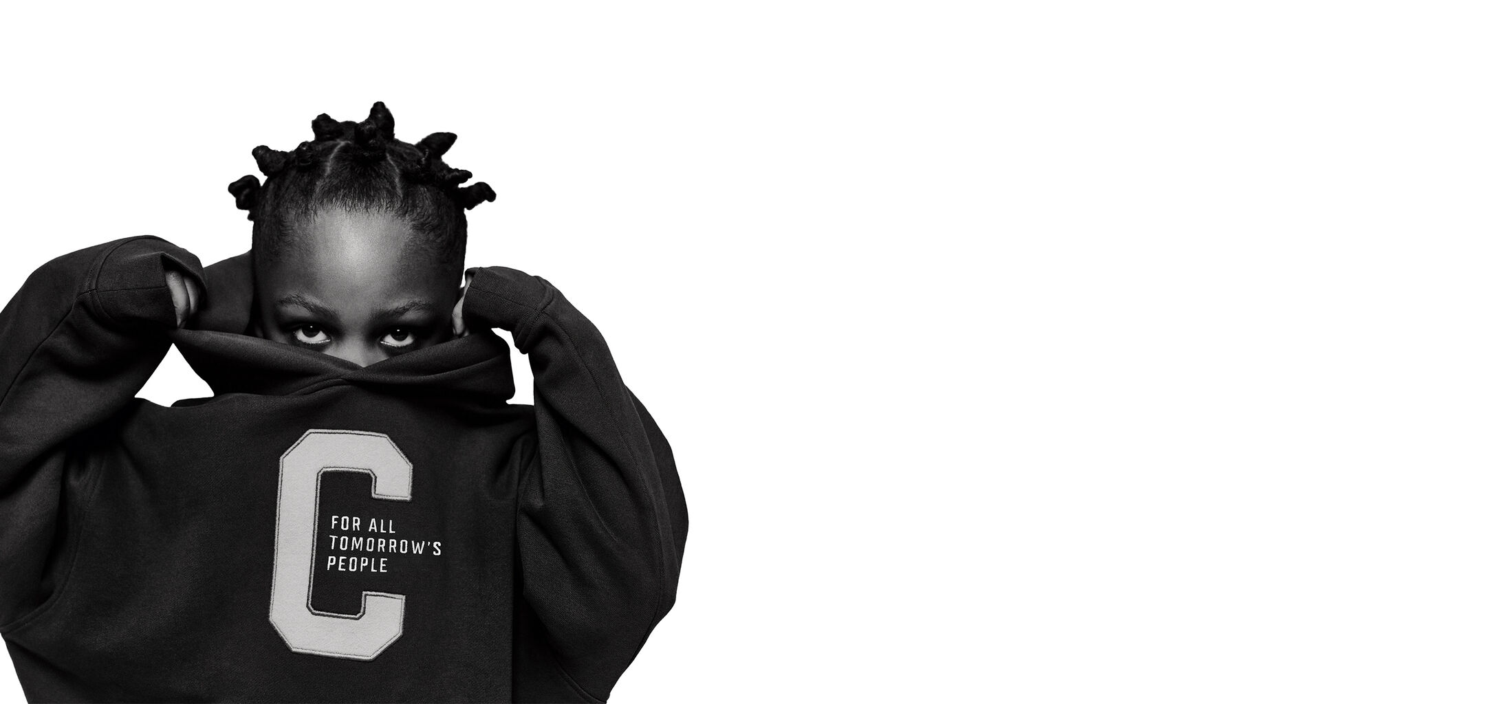 Een kind dat rechtstreeks in de camera kijkt. De helft van zijn gezicht zit verborgen onder een CYBEX-hoodie die hij over zijn hoofd trekt.