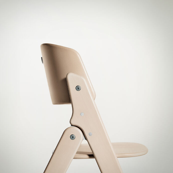 Click and Fold high chair in light wood, side view.