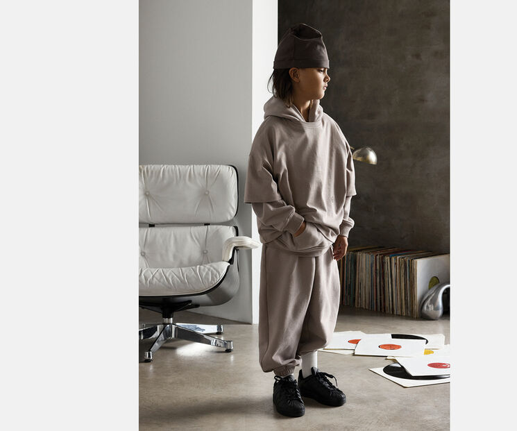 A young boy in casual clothing. Full body shot while he's looking to the side.