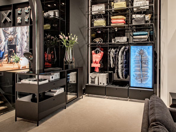 CYBEX Flagship Store Amsterdam with modern shelving showcasing colorful bags and baby products.