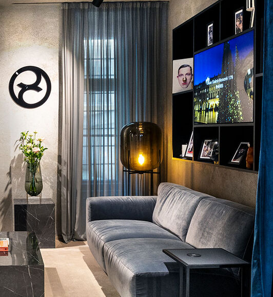 A sofa with a display case behind it and a CYBEX logo at the wall.