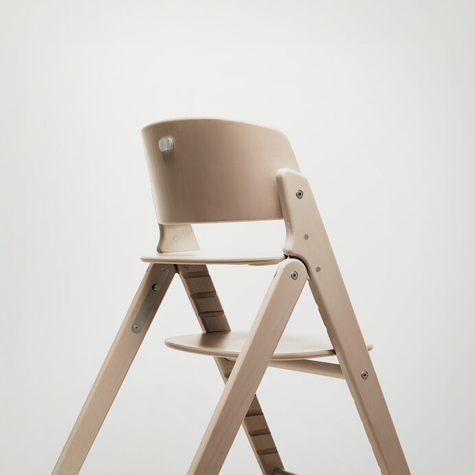 Click and Fold high chair in light wood design, side view.