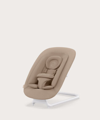 Dětské lehátko světle béžové barvy s ergonomickým designem a bezpečnostním pásem.