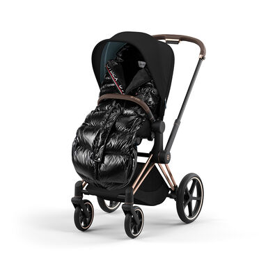 Pushchair with a black, shiny footmuff and brown handle.