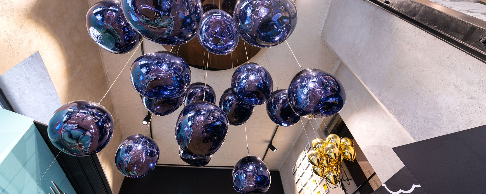Image of a ceiling art piece that looks like multiple balloons made out of glass in blue.