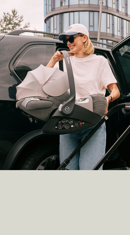 A mother taking out her Cloud T infant car seat of the car.