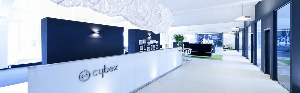 Reception area of a modern office with the "cybex" logo on the counter.