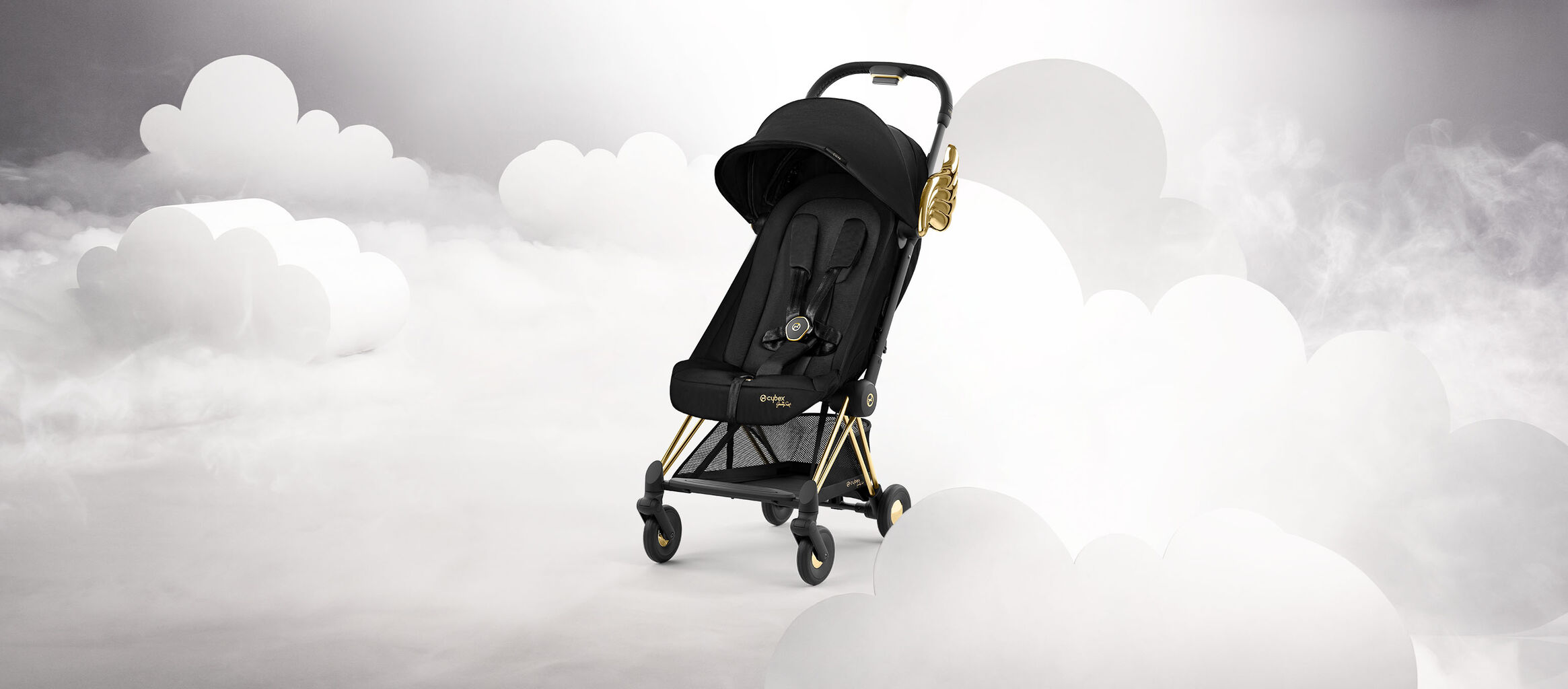 Black stroller by Jeremy Scott Wings with gold accents, surrounded by white clouds.