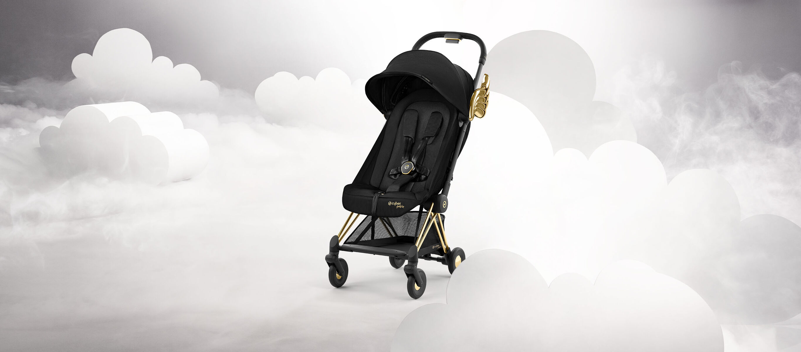Black stroller by Jeremy Scott Wings with gold accents, surrounded by white clouds.