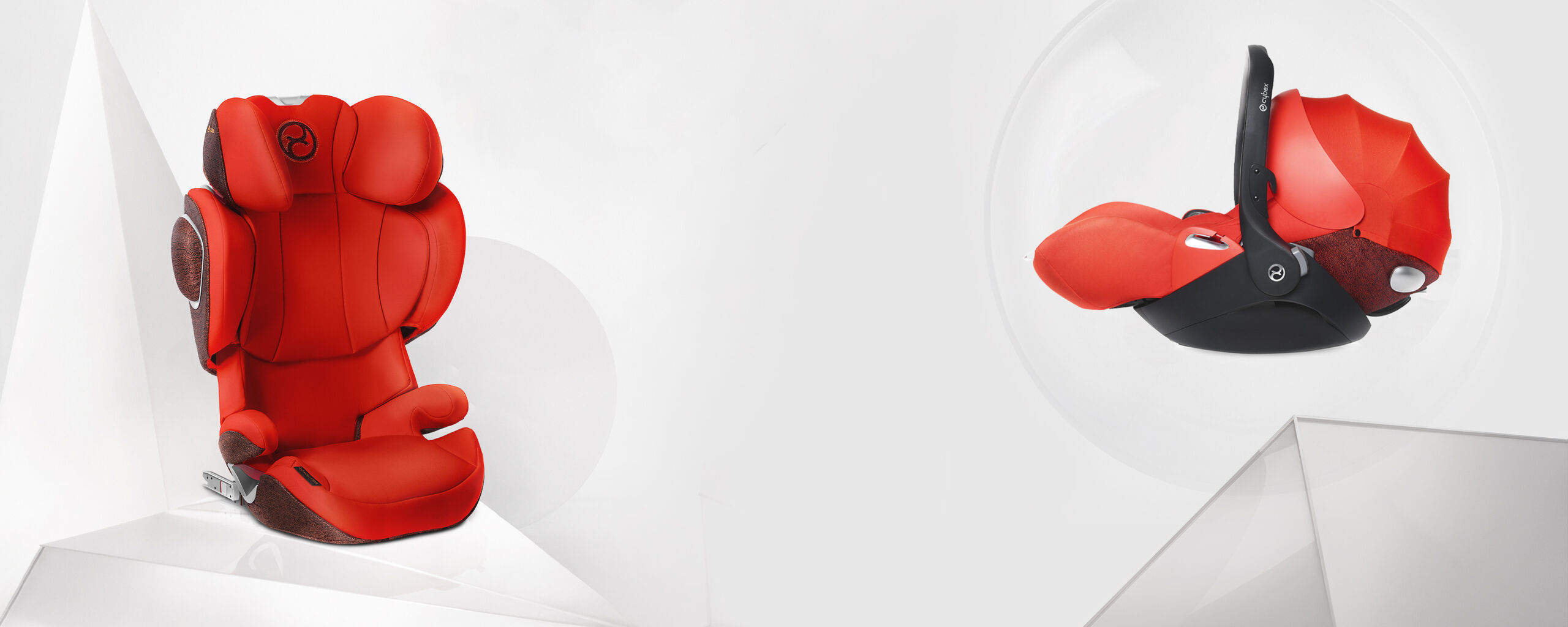 A red child car seat and a red baby carrier on a white background.