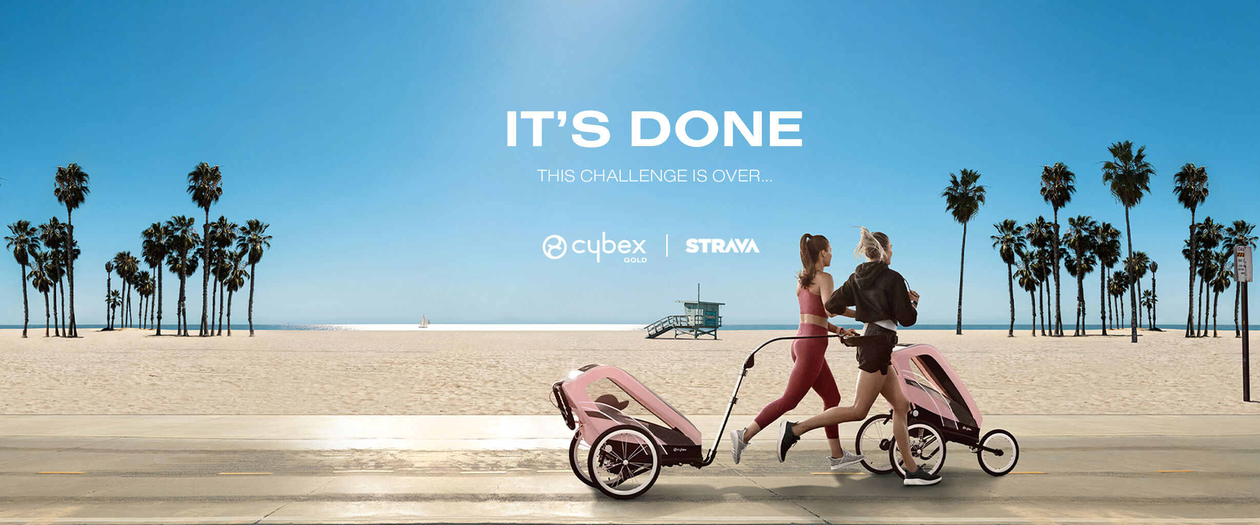 Two women, viewed from behind, jog with their pushchairs on a sunny beach with palm trees and a blue sky featuring the large text "IT'S DONE THIS CHALLENGE IS OVER..." and the Cybex Gold Strava logo.
